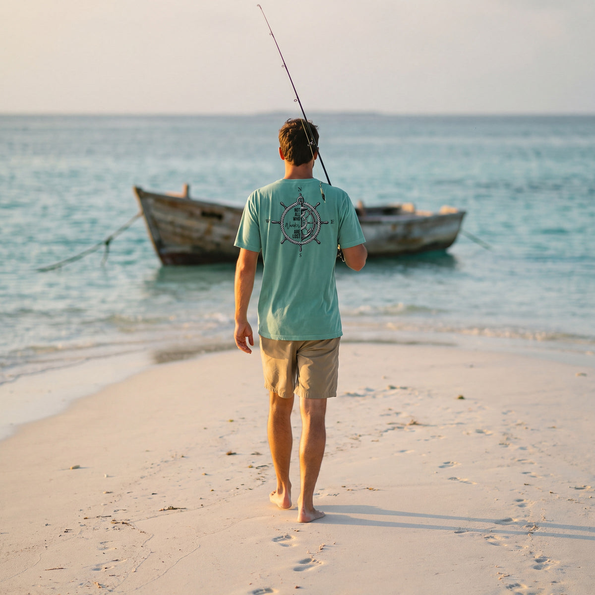 Angler walking a sandbar toward a skiff in the seafoam Not All Who Wander Are Lost tee
